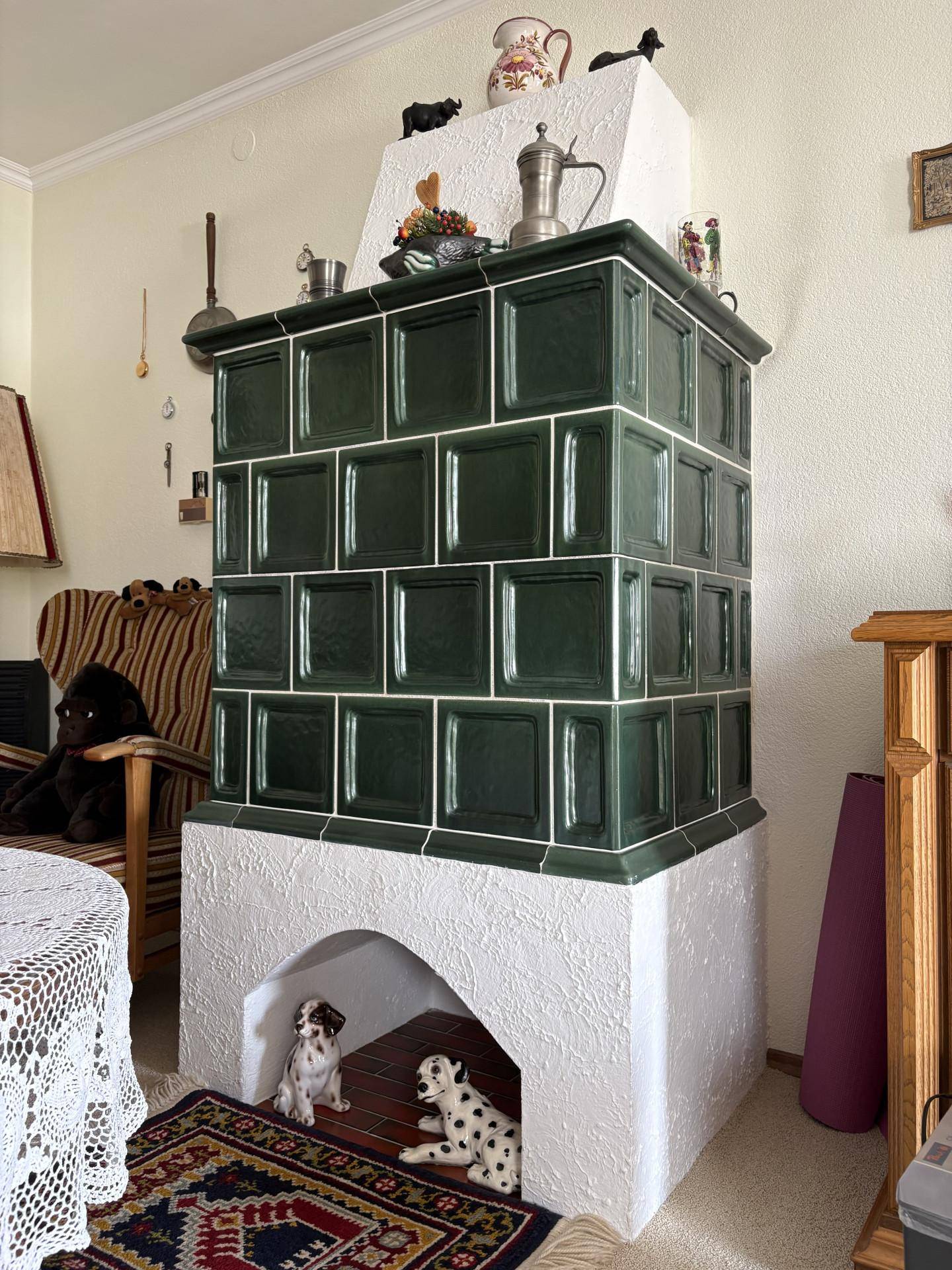 Traditioneller grüner Kachelofen als gemütliches Heizelement in einem Wohnzimmer mit alpiner Note.
