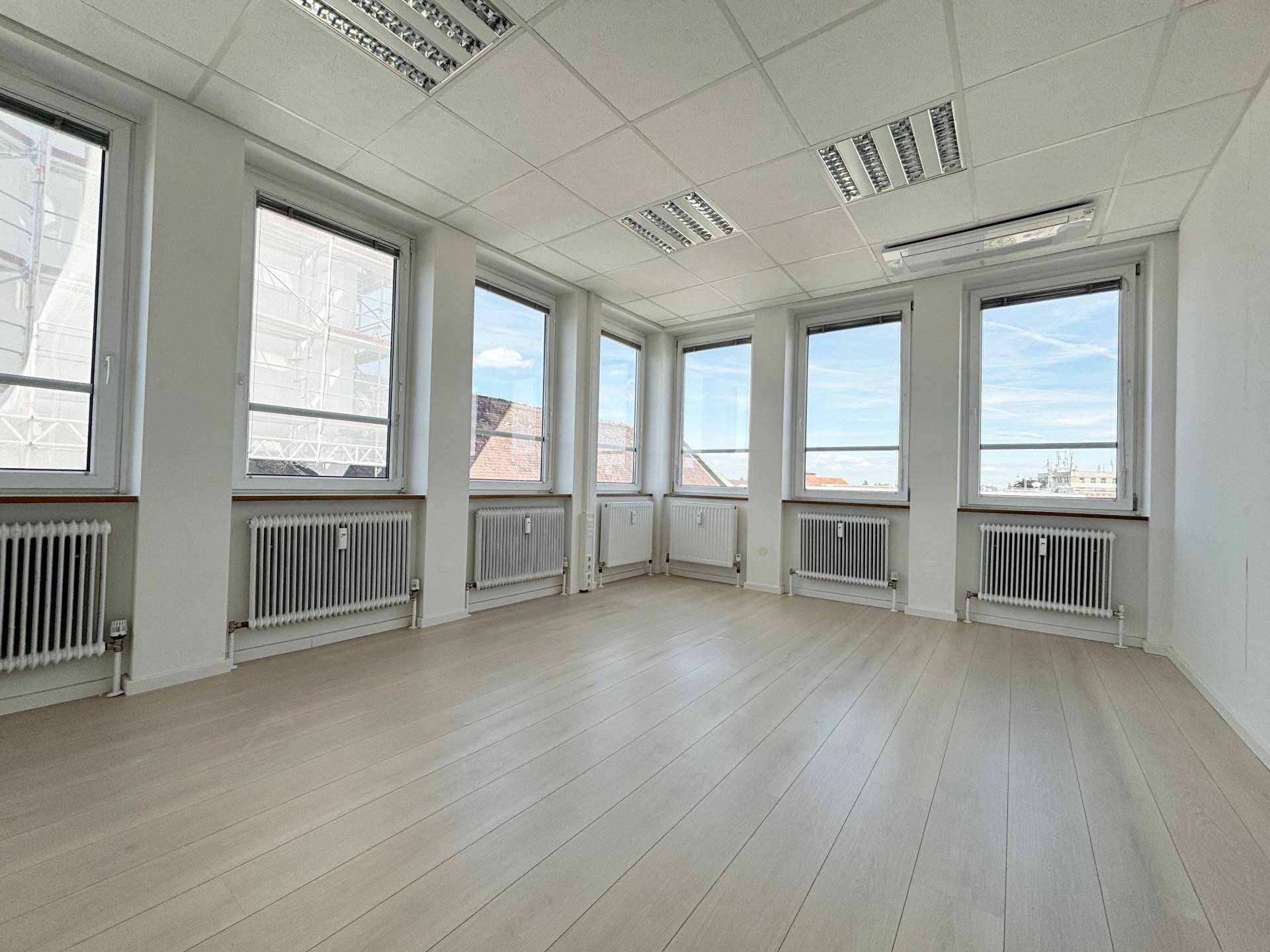 Helles Eckbüro mit vielen Fenstern, die viel Tageslicht hereinlassen und eine weite Aussicht bieten.