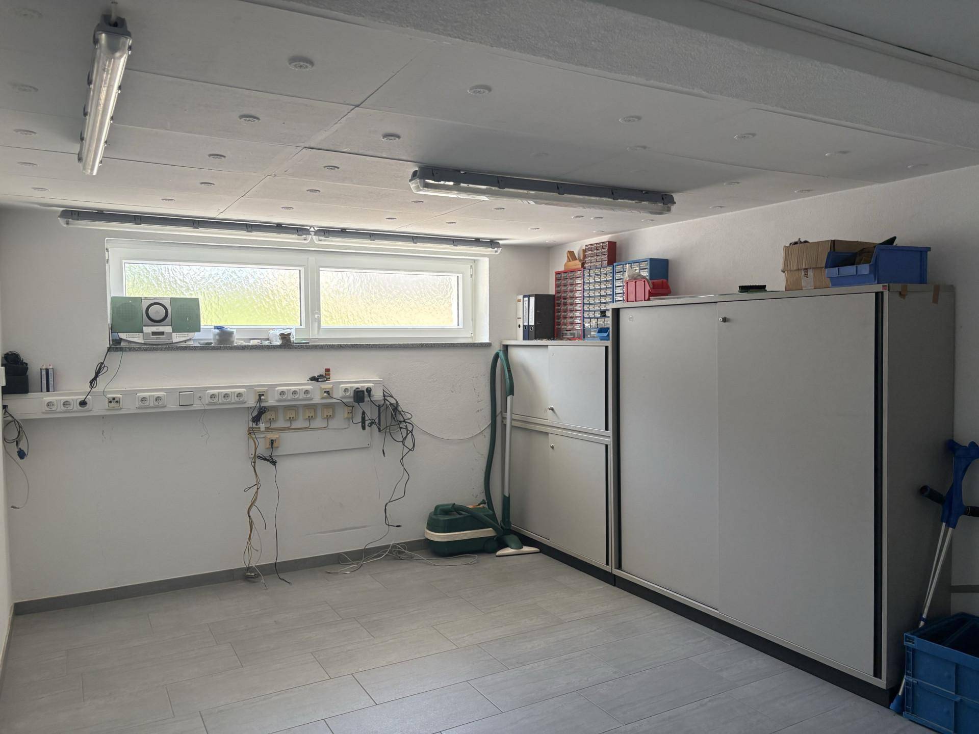 Praktischer Hauswirtschaftsraum mit Fliesenboden, Fenster und viel Stauraum.