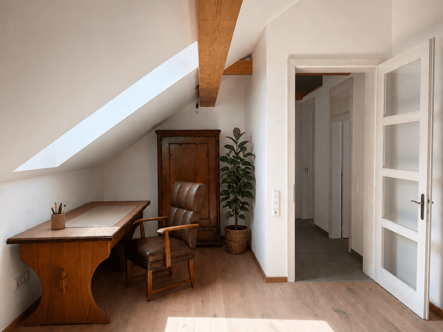 Ruhiges Arbeitszimmer im Dachgeschoss mit Holzbalken, Schreibtisch und Blick auf den Flur.