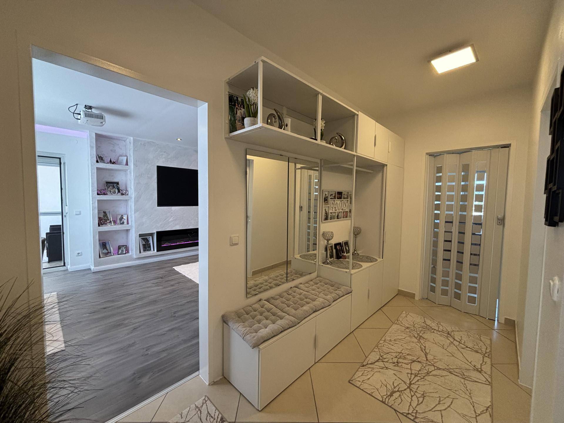 Heller Eingangsbereich mit Garderobe, Spiegeln und Zugang zum Wohnbereich.
