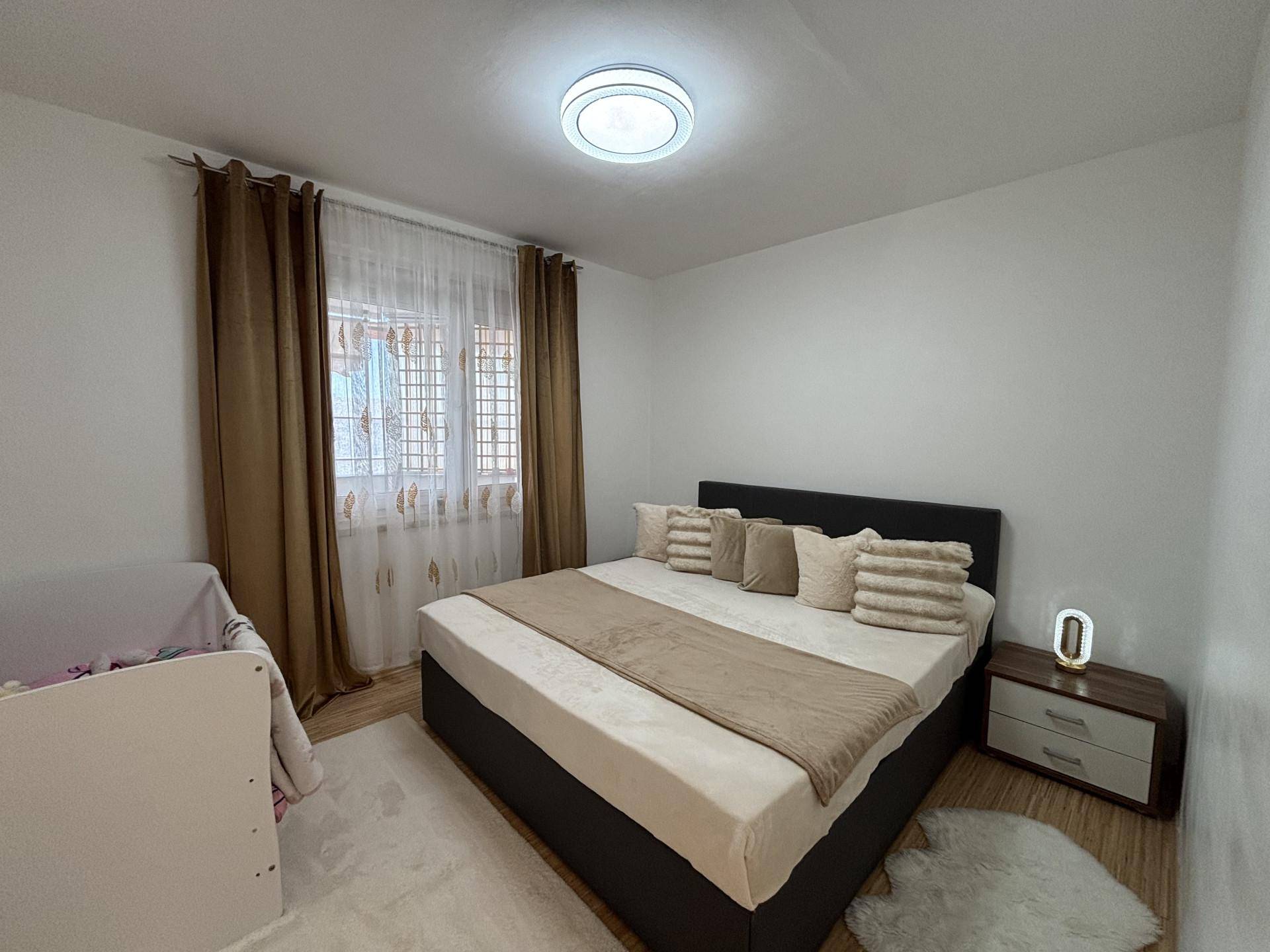 Gemütliches Schlafzimmer mit Doppelbett, Nachttisch und hellem Holzboden.
