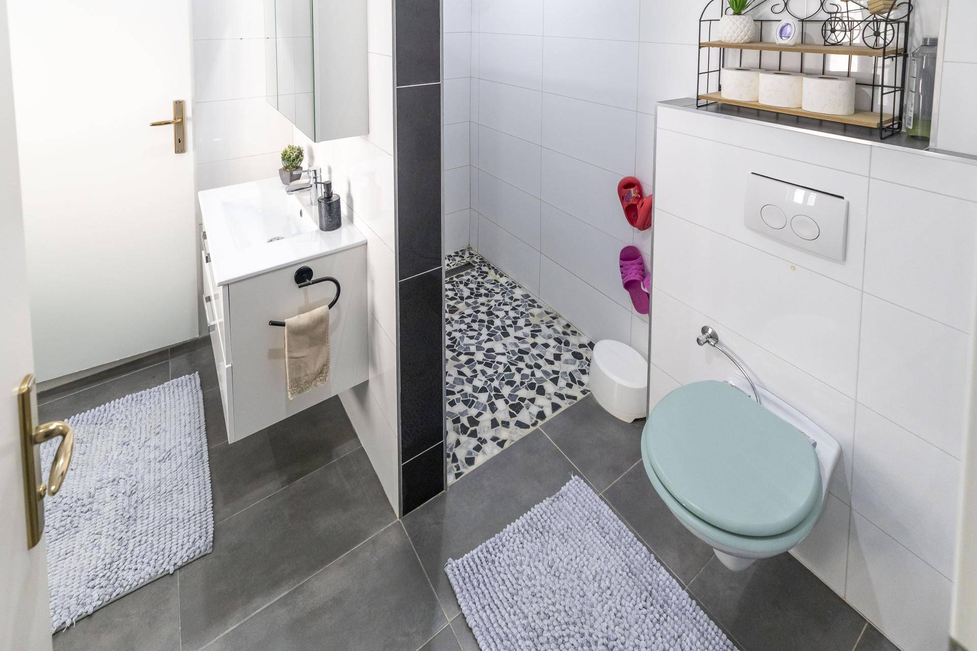 Modernes Badezimmer mit begehbarer Dusche und wandhängendem WC.