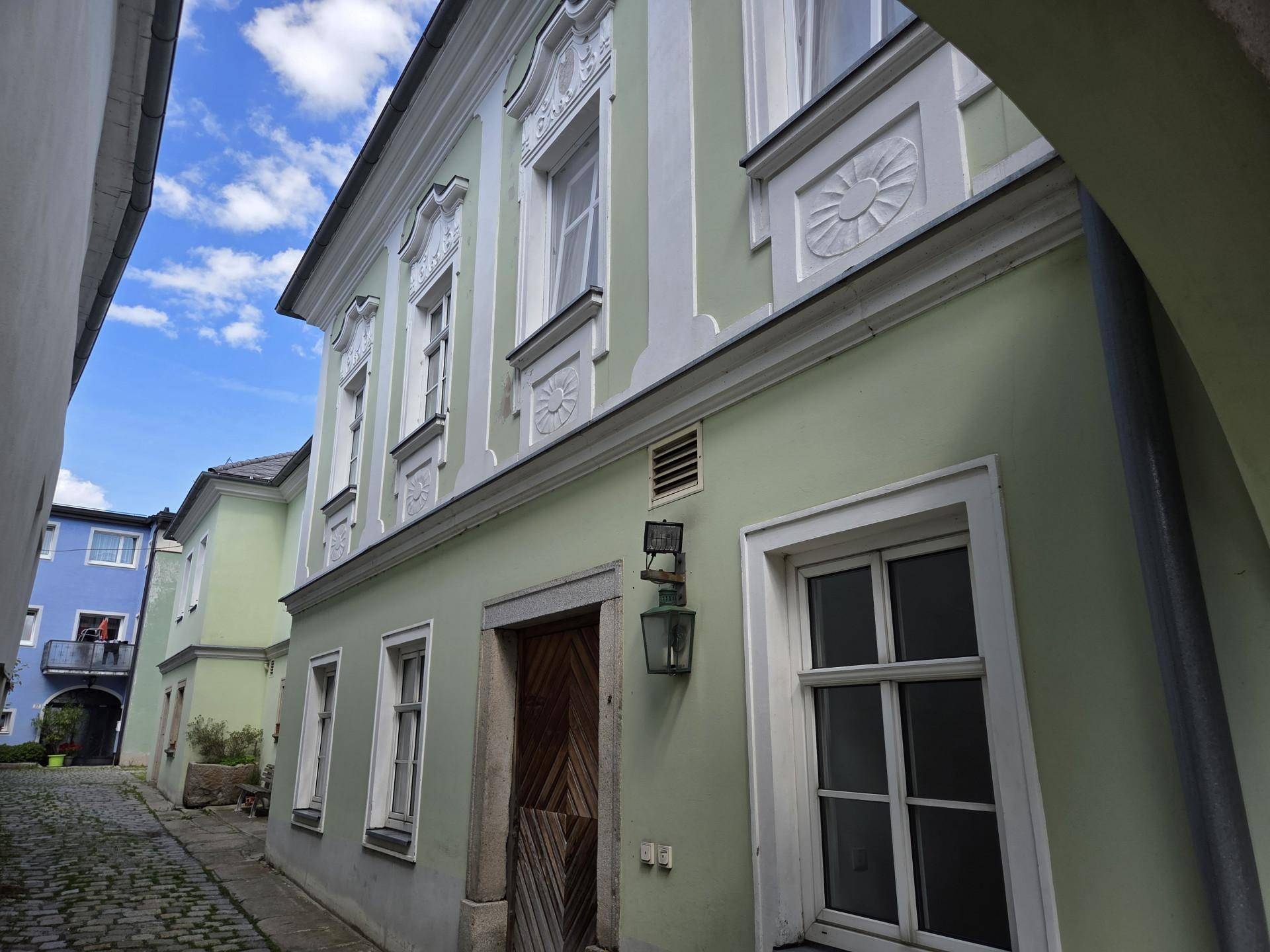 Seitenansicht des historischen Gebäudes mit gepflasterter Gasse und dekorativen Elementen.