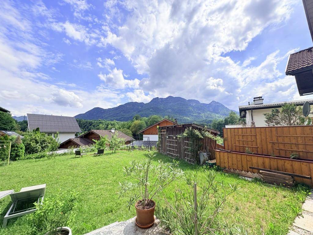 Großer grüner Garten mit Rasenfläche und weitem Blick auf die umliegende Berglandschaft.