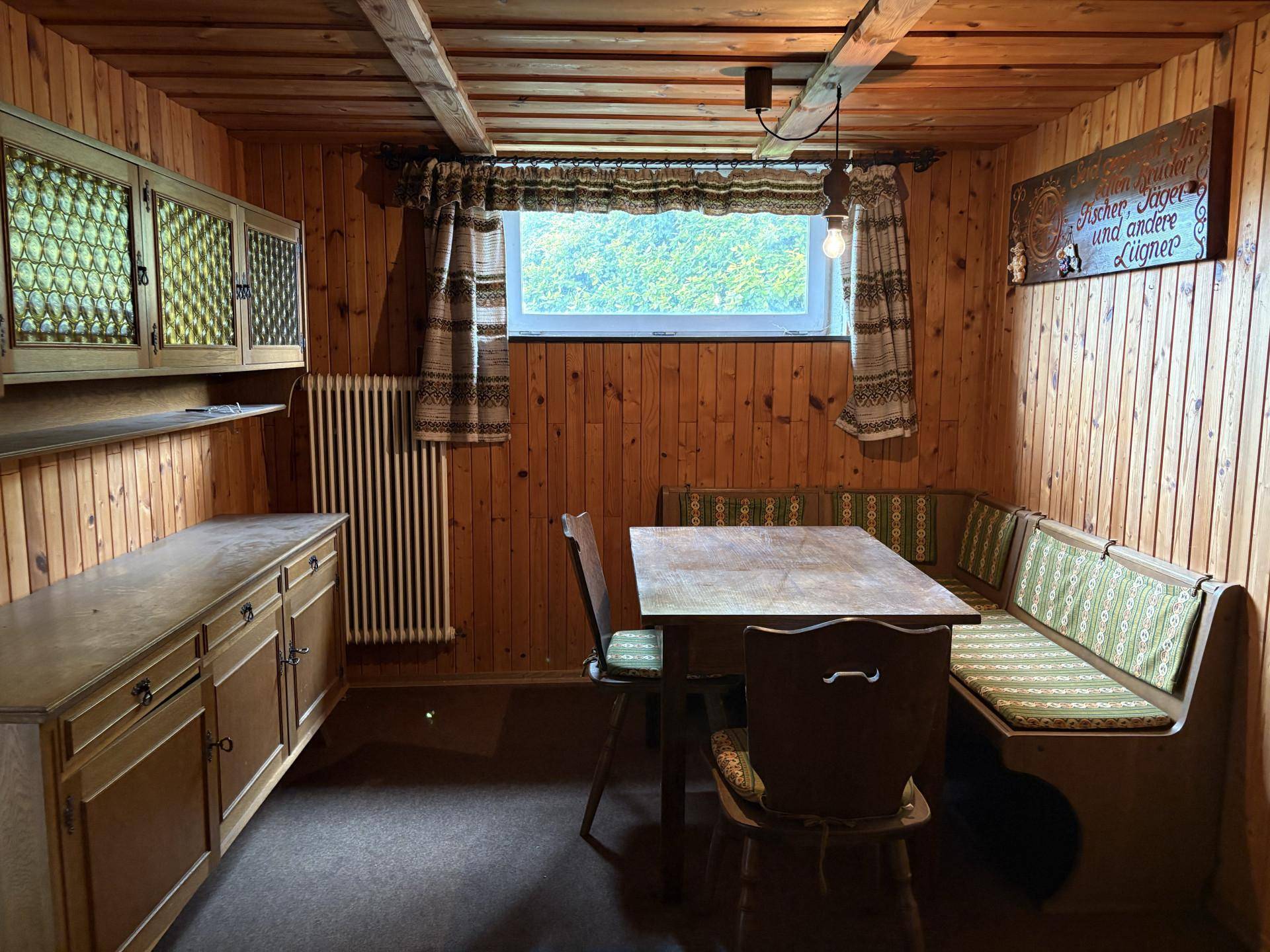 Rustikaler Essbereich mit Holztäfelung, Eckbank und traditionellen Möbeln, der eine gemütliche Atmosphäre schafft.