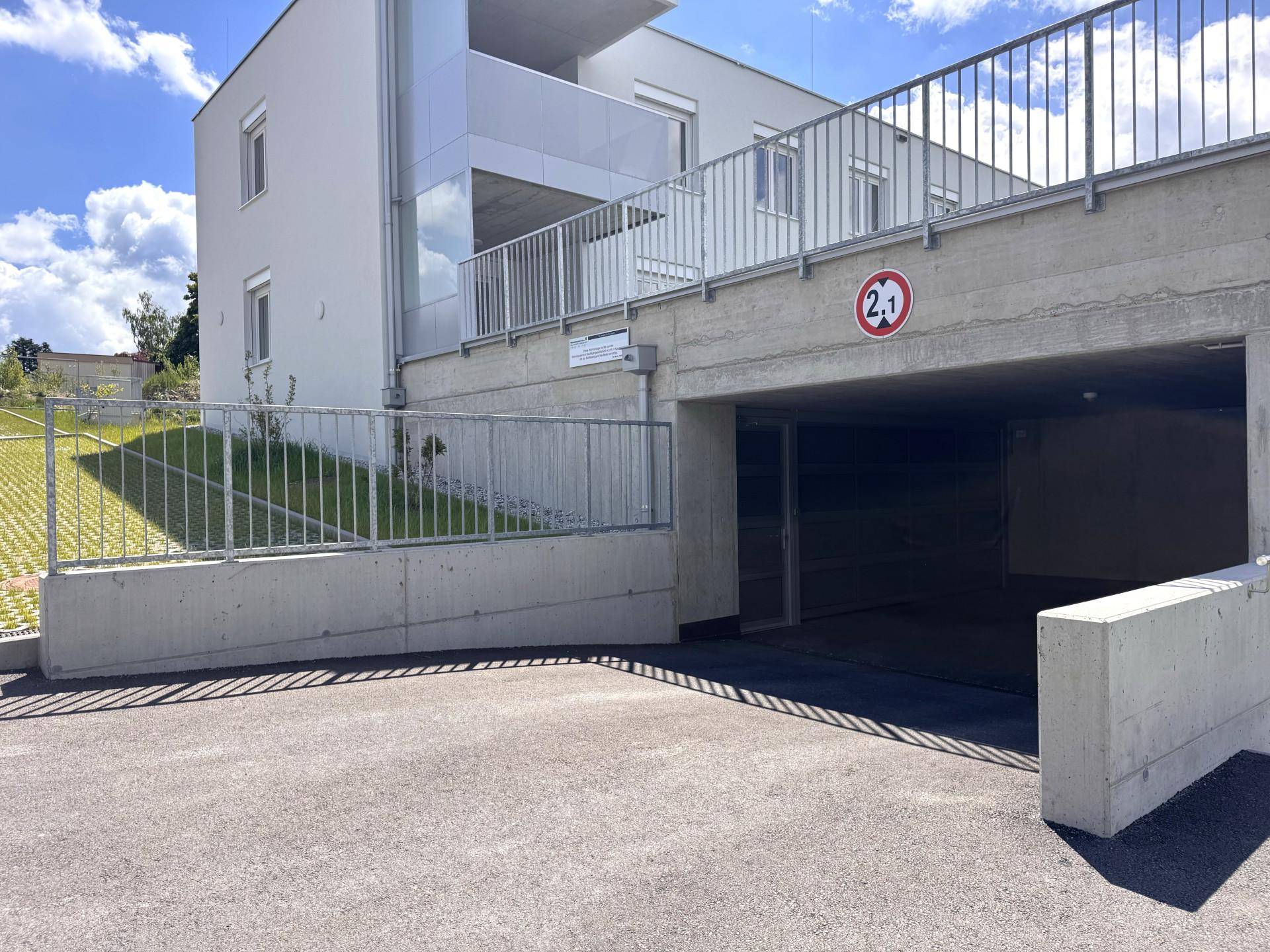 Zufahrt zur Tiefgarage eines modernen Wohngebäudes mit ausreichend Parkmöglichkeiten für Bewohner.