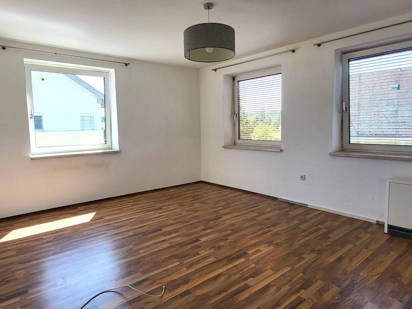 Geräumiger, heller Raum mit Laminatboden und mehreren Fenstern, bereit zur individuellen Gestaltung.