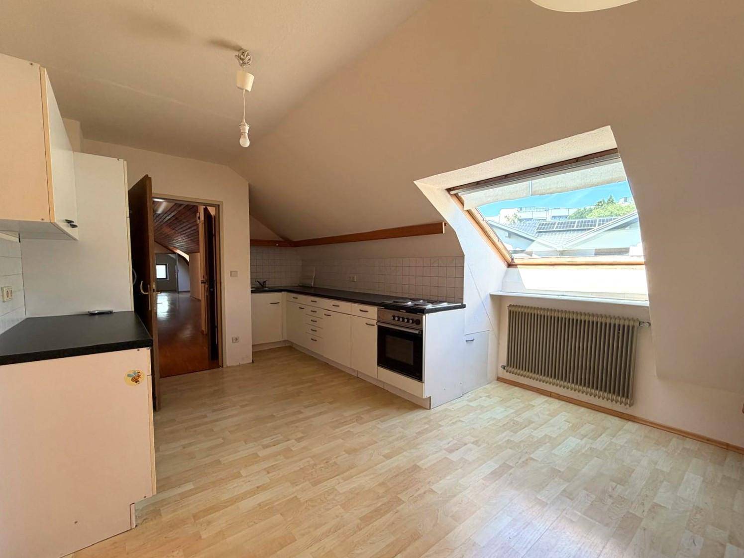 Dachgeschossküche mit einfacher Ausstattung, Dachschräge und einem Dachfenster.