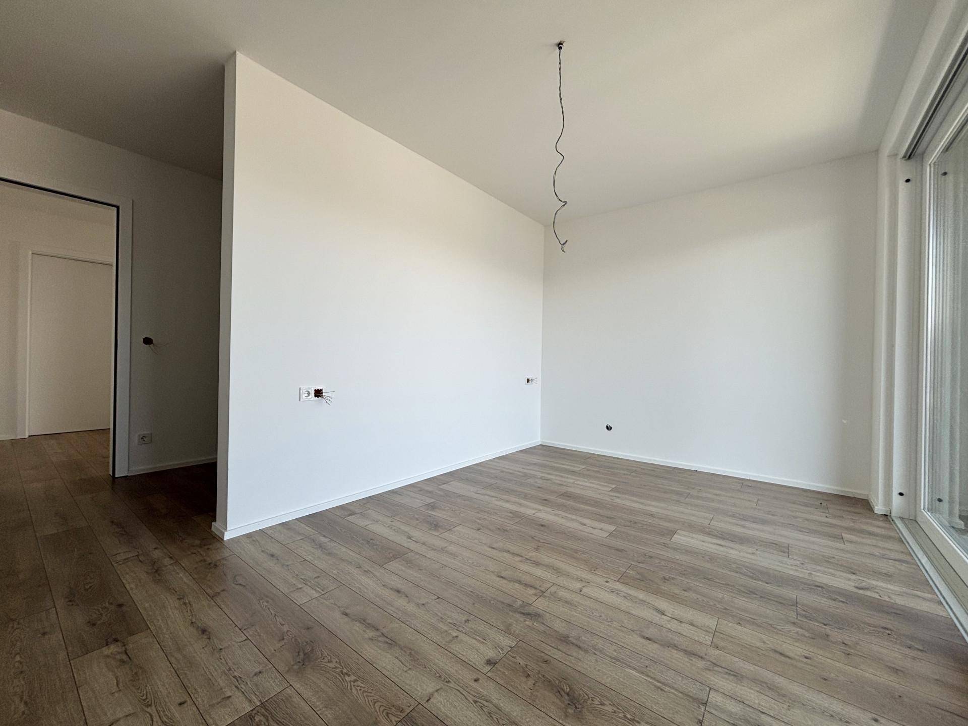 Helles Zimmer mit Laminatboden und weiß gestrichenen Wänden, bereit zum Einzug.