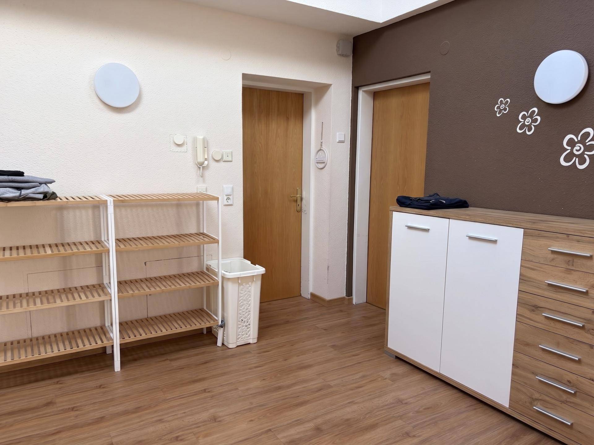 Eingangsbereich mit Holzboden, Schuhregalen und Kommode, ideal für zusätzlichen Stauraum.