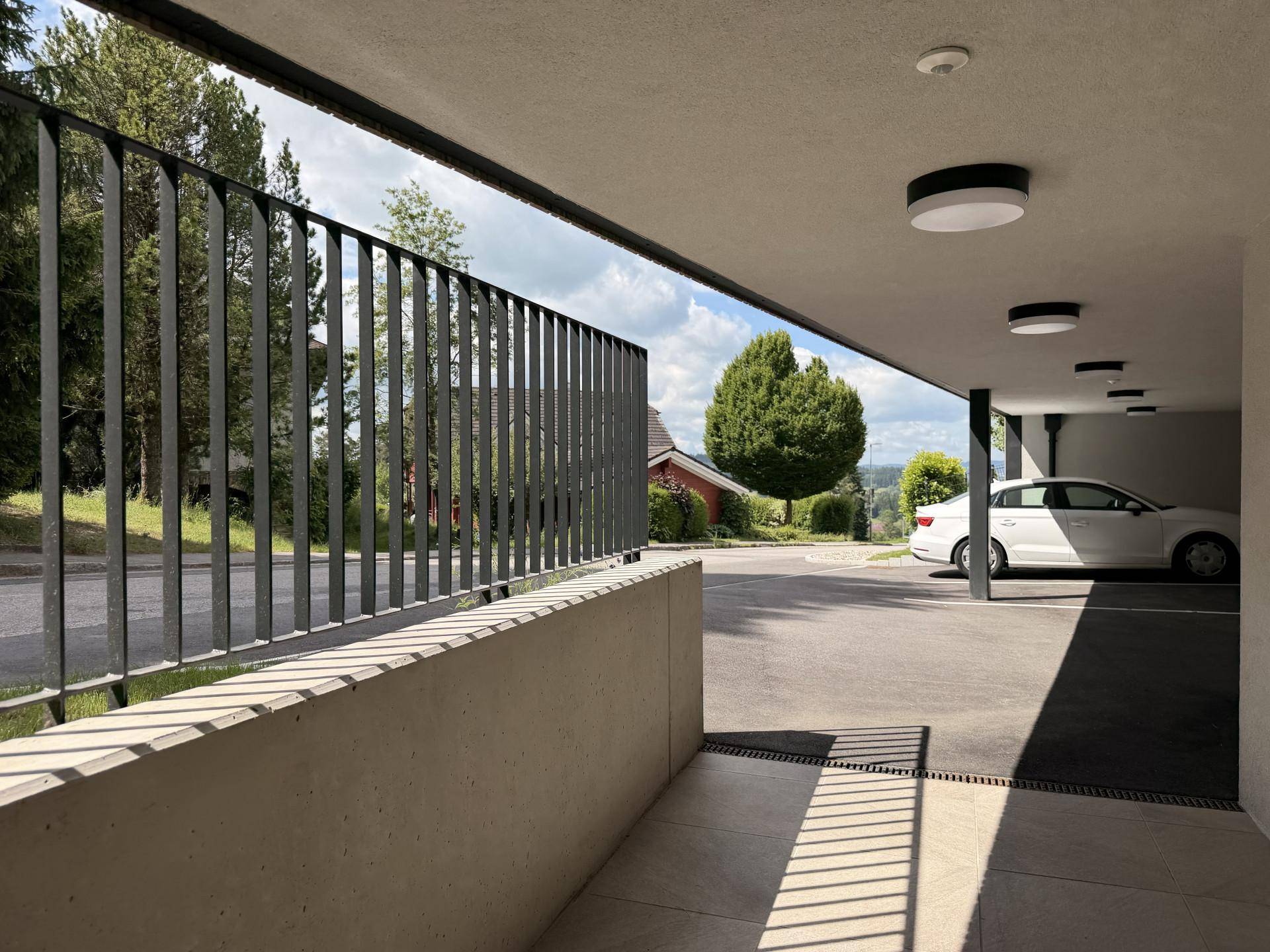 Überdachter Parkplatz oder Carport mit modernem Design und Blick auf die Straße.