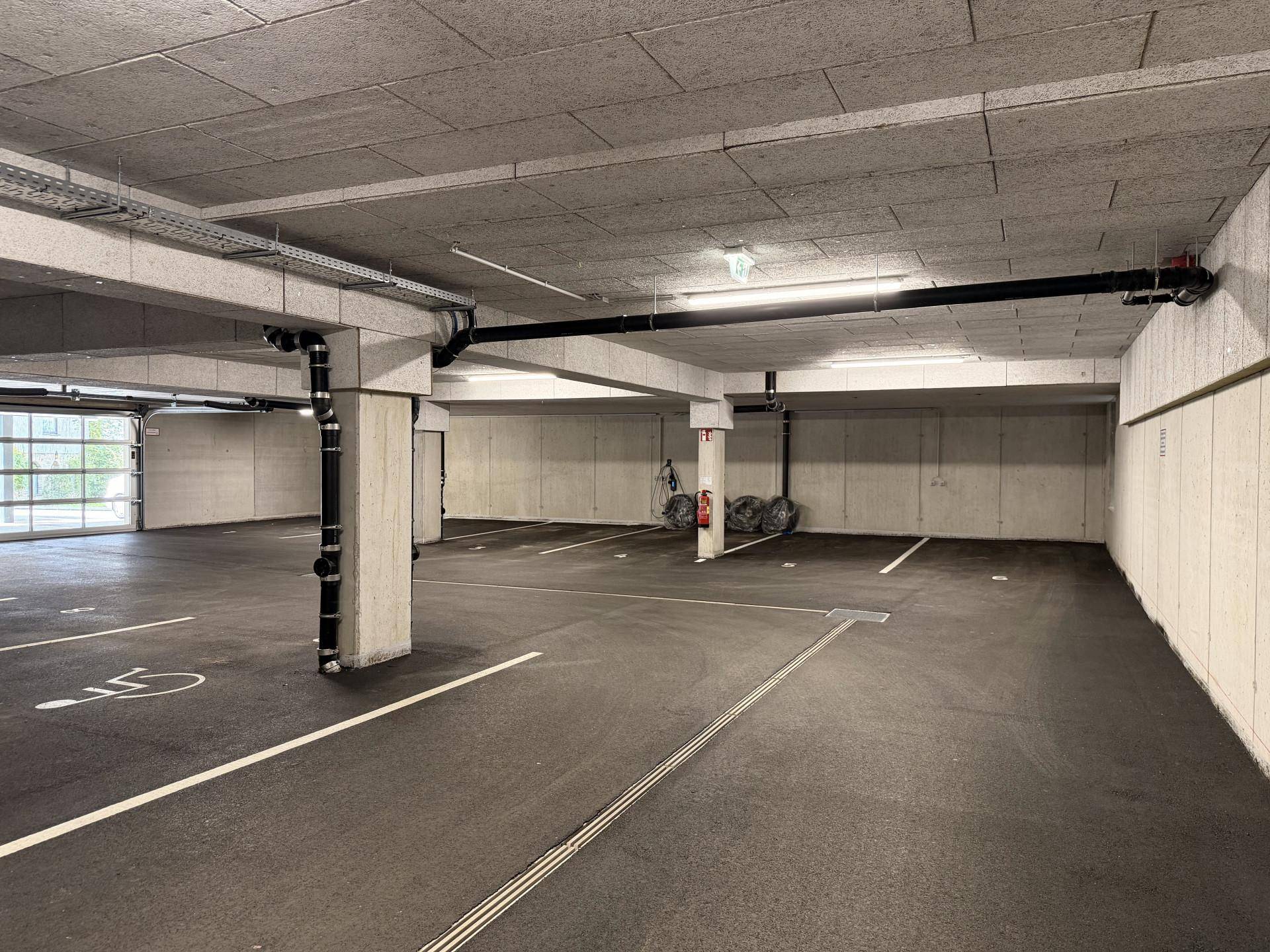 Tiefgarage mit markierten Parkplätzen und Zufahrt.