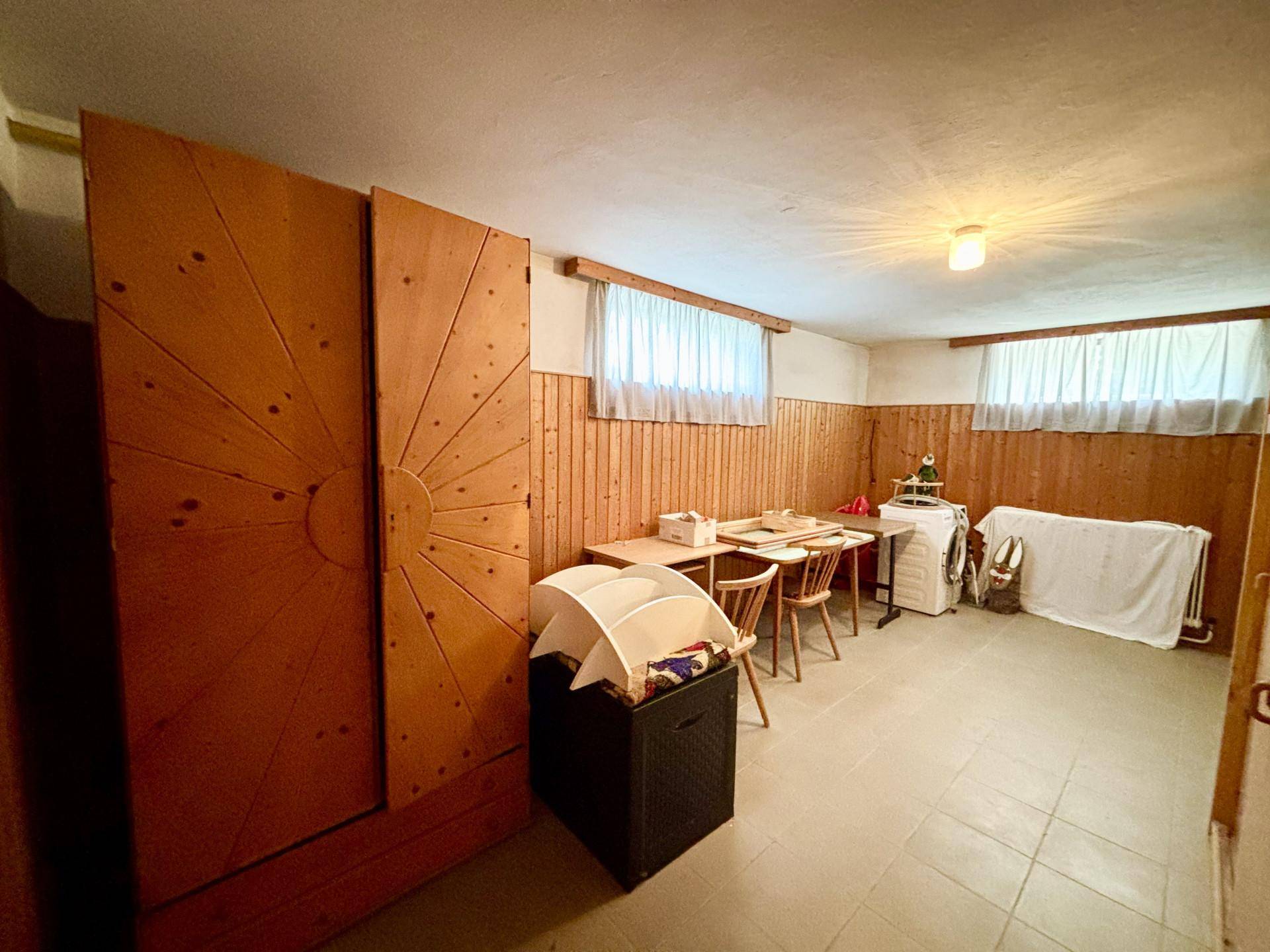 Hauswirtschaftsraum im Keller mit Waschmaschine, Trockner und Holzvertäfelung.