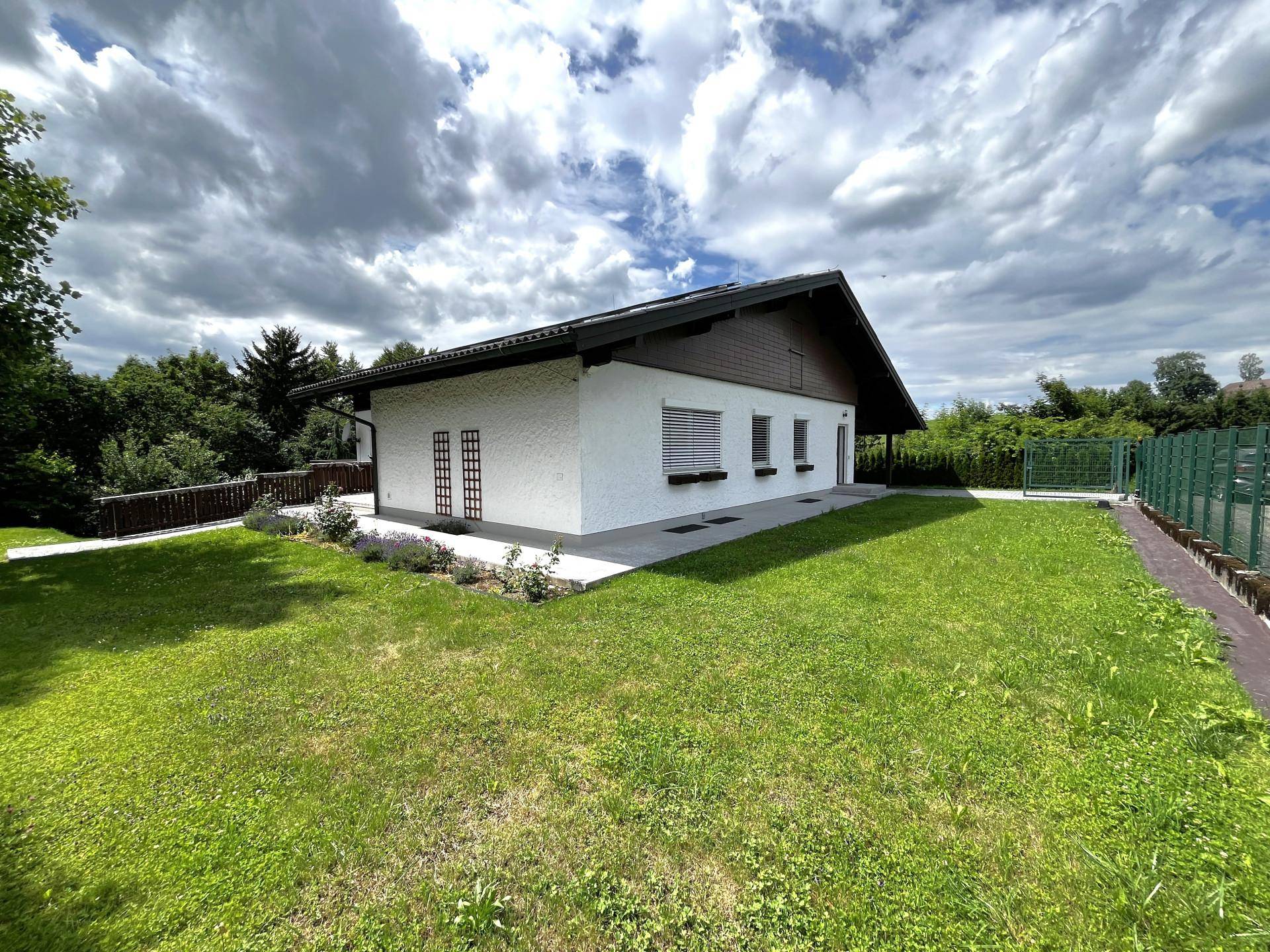 Seitenansicht des Hauses mit großem Garten und gepflegter Rasenfläche.