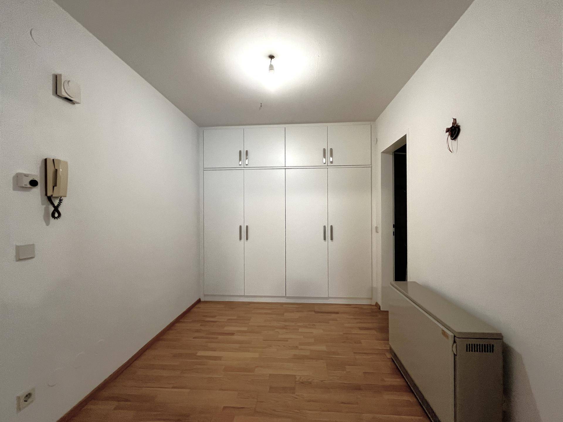 Schlafzimmer mit Einbauschränken, Holzboden und viel Stauraum.