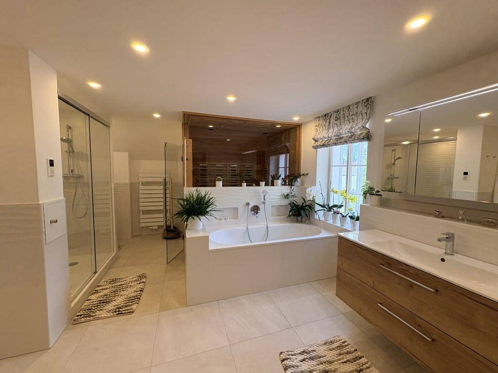 Großes, modernes Badezimmer mit Badewanne, begehbarer Dusche, Doppelwaschbecken und integrierter Sauna.