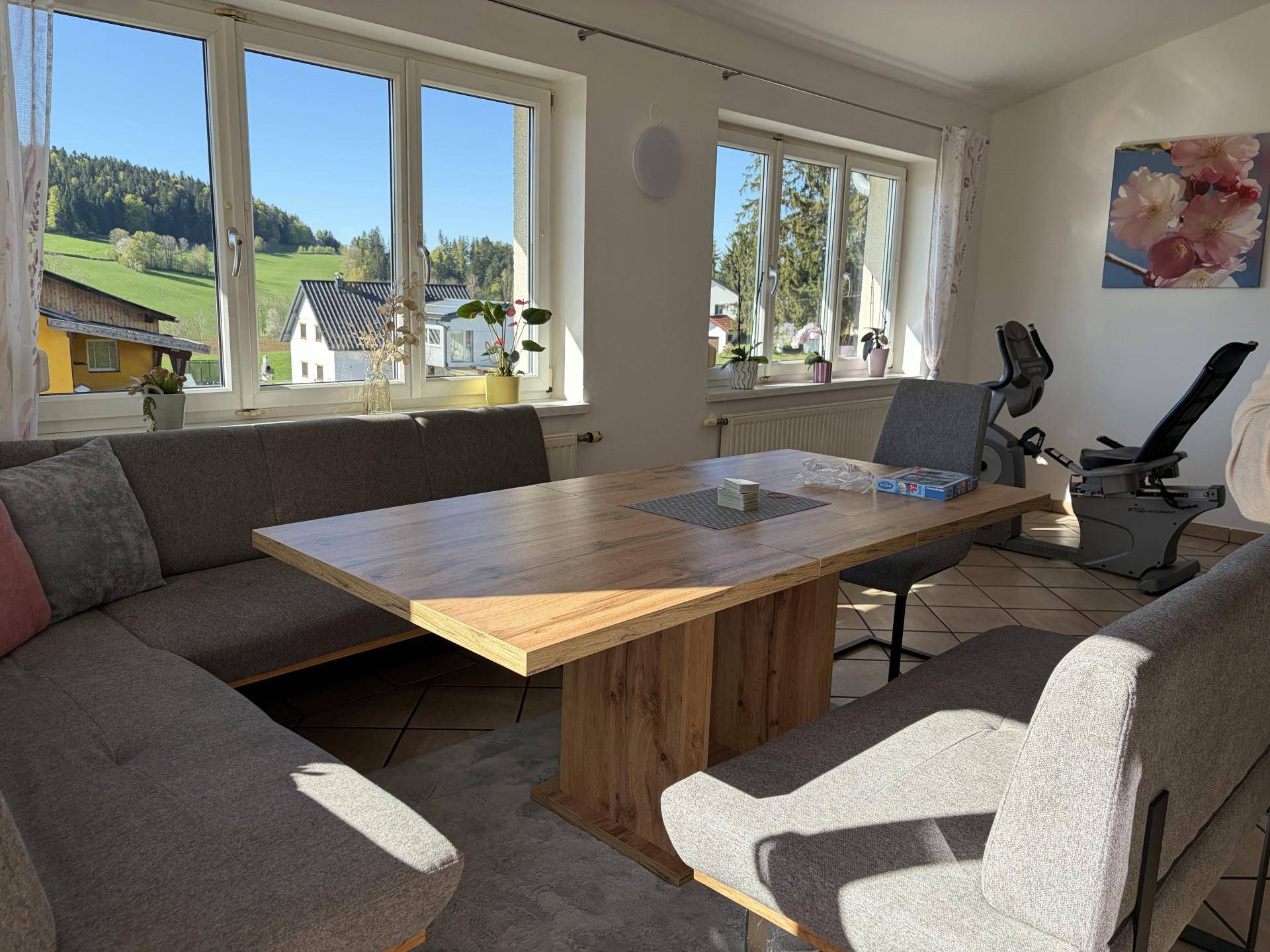 Gemütlicher Essbereich mit großem Holztisch, Eckbank und weitem Blick in die Natur.