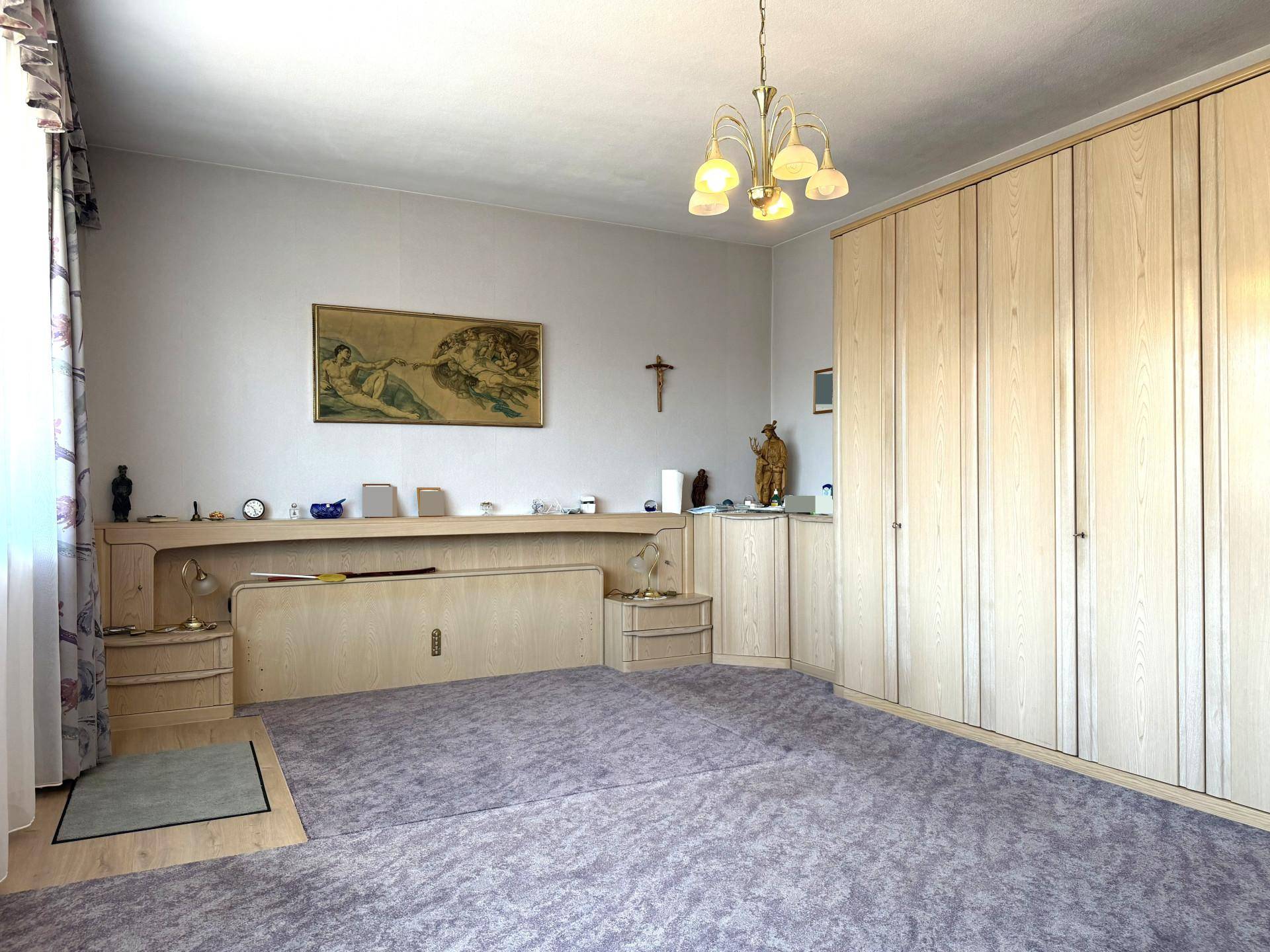Schlafzimmer mit Einbauschränken, Teppichboden und klassischer Einrichtung.