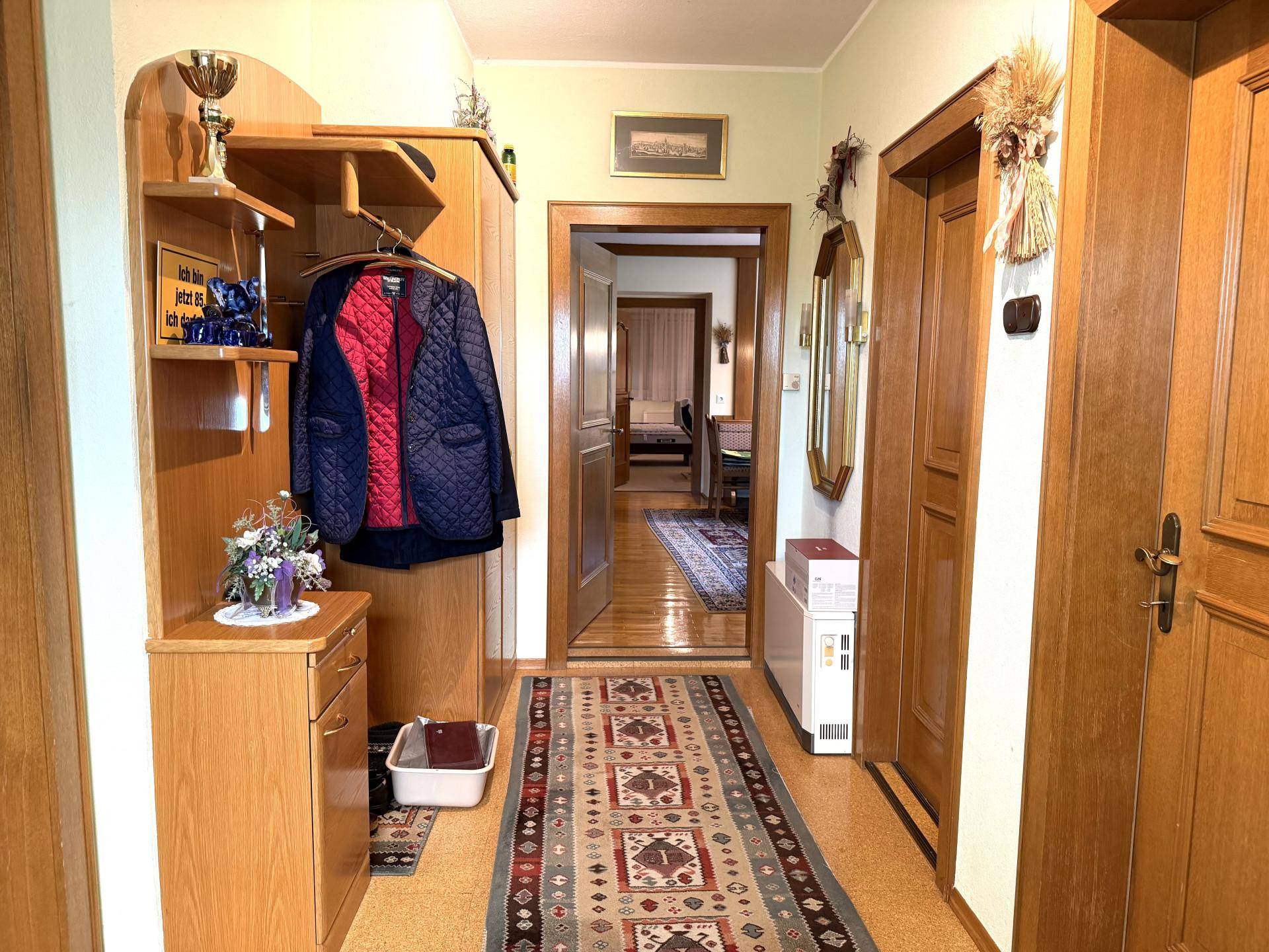 Einladender Flur mit Korkboden, Holzvertäfelung und Garderobe.