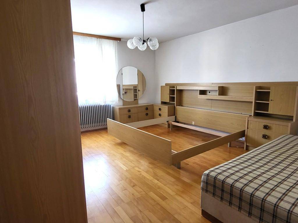 Helles Schlafzimmer mit Holzboden, Einbauschränken und großem Fenster, praktisch und geräumig.