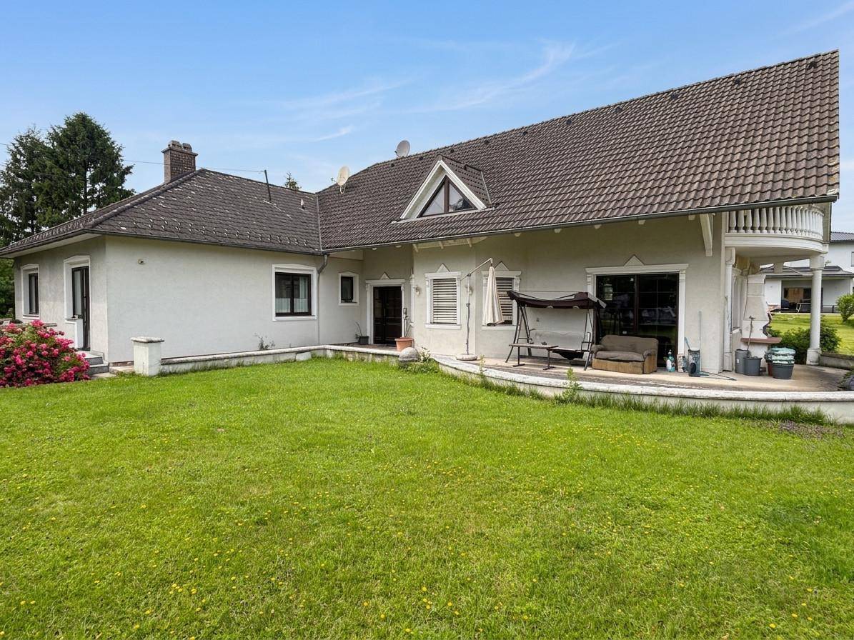 Ansicht des Einfamilienhauses von der Seite mit großem Garten und Terrasse.