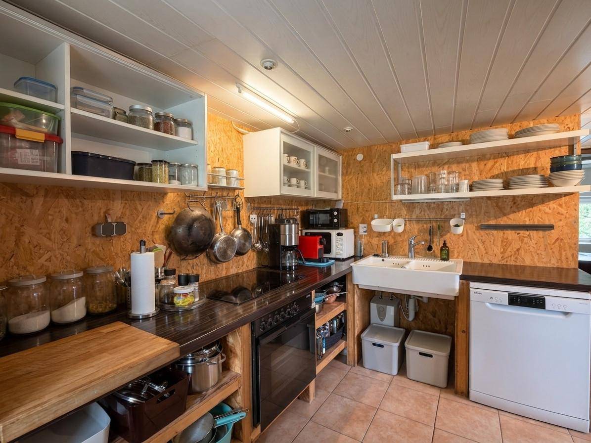 Rustikale Küche mit offenen Regalen, Holzplatten und modernen Einbaugeräten.