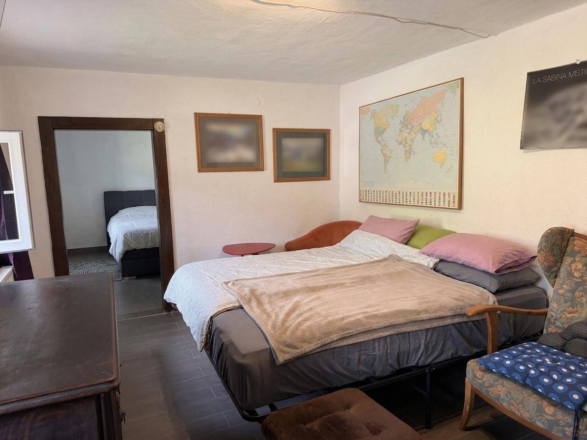Geräumiges Schlafzimmer mit Doppelbett, Sessel und Weltkarte an der Wand.