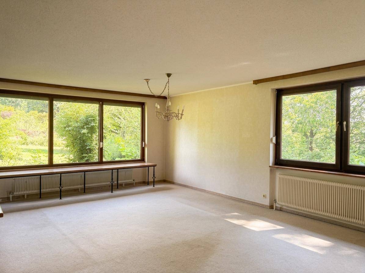Helles Wohnzimmer mit Teppichboden und großen Fenstern, die viel Tageslicht hereinlassen.