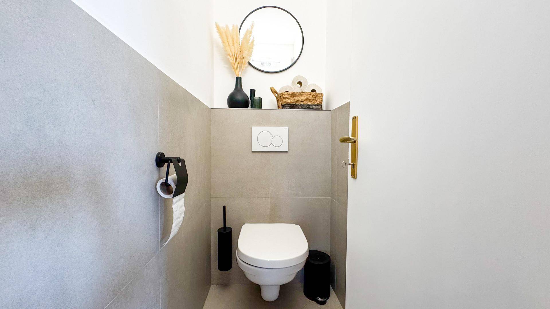 Modernes Gäste-WC mit Wand-WC, grauen Fliesen und minimalistischer Dekoration.