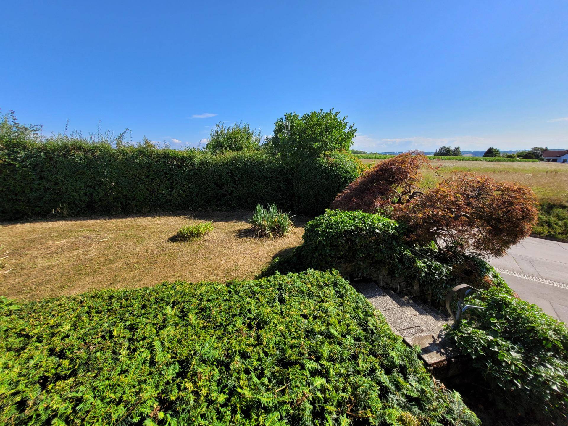 Großer Gartenbereich mit hohen Hecken und weitem Blick in die Landschaft.