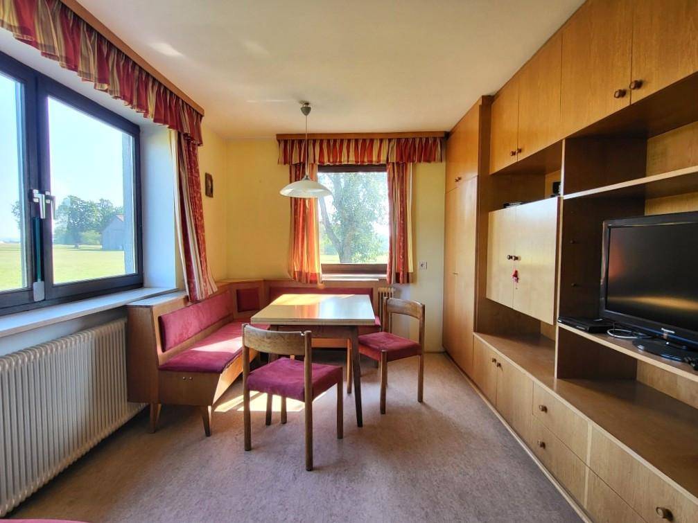 Essbereich mit eingebauter Sitzbank, Holzmöbeln und großem Fenster mit Weitblick.