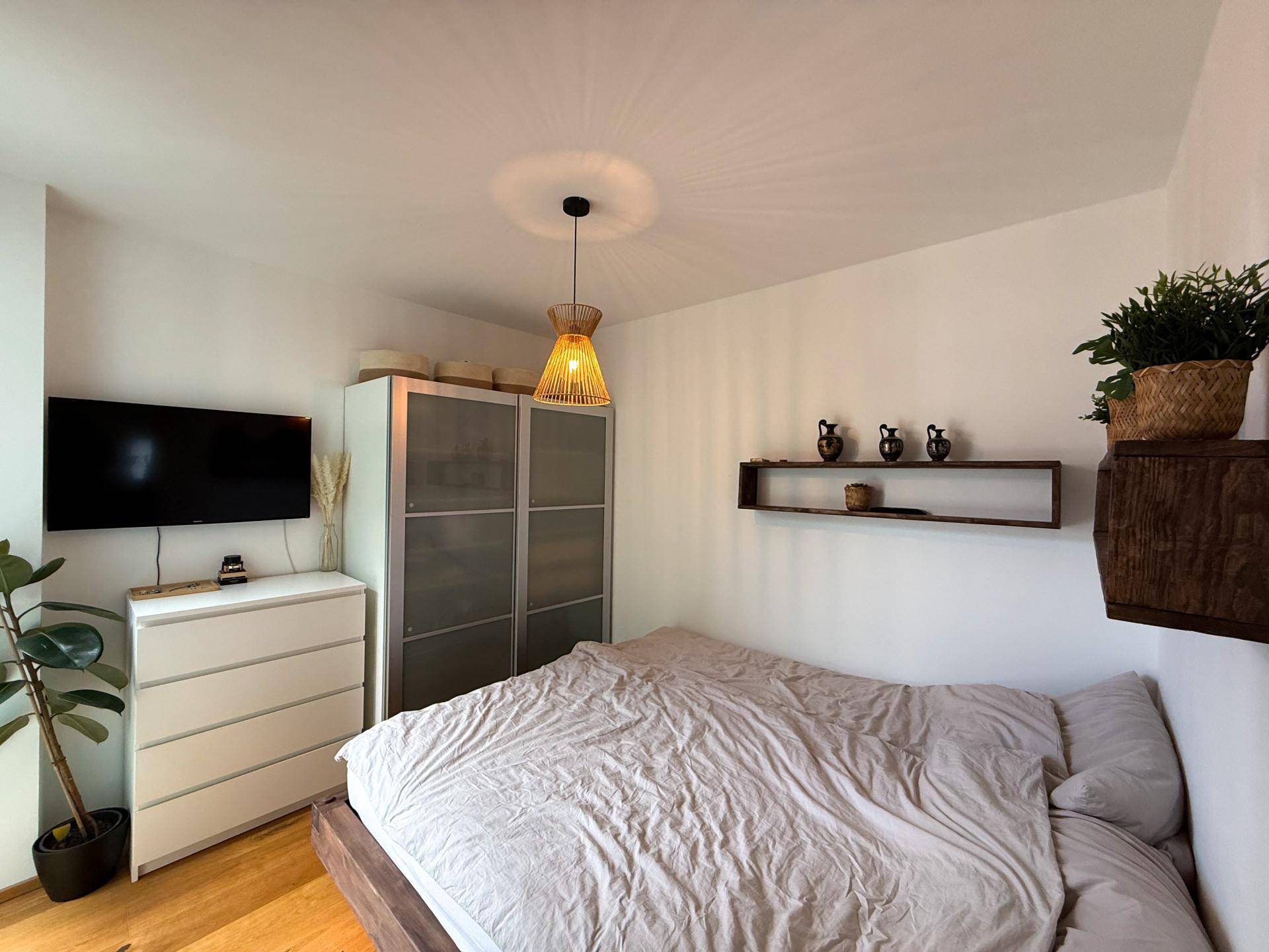 Gemütliches Schlafzimmer mit Doppelbett, weißer Kommode und modernem Kleiderschrank.