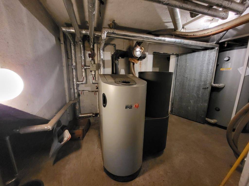 Heizraum im Keller mit Heizkessel, Rohren und Warmwasserspeicher.