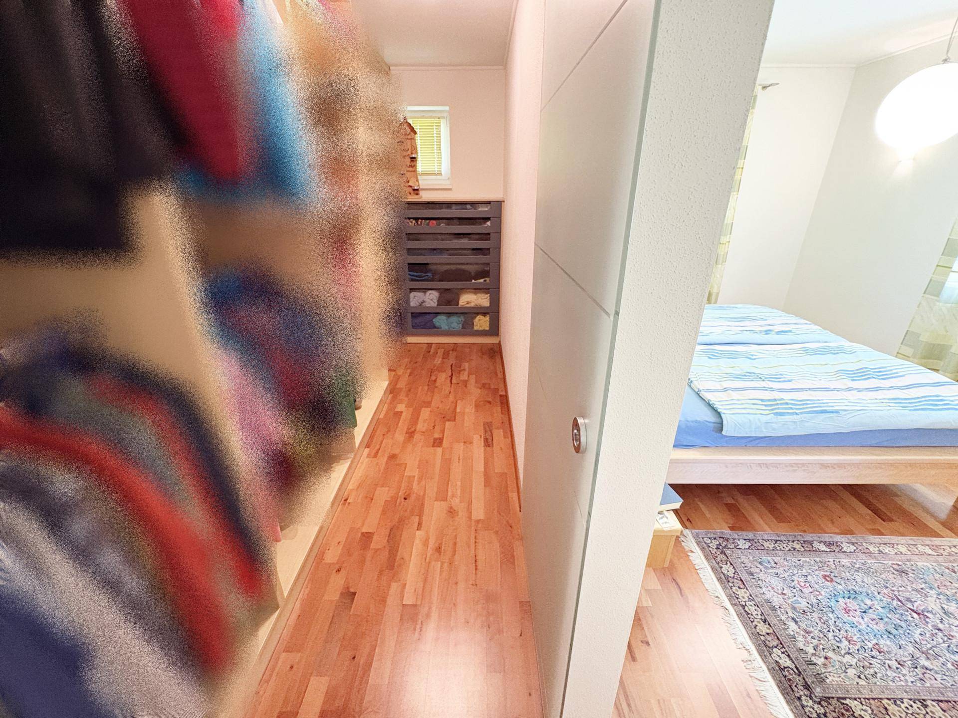 Praktischer begehbarer Kleiderschrank mit Regalsystemen, direkt angrenzend an das Schlafzimmer.
