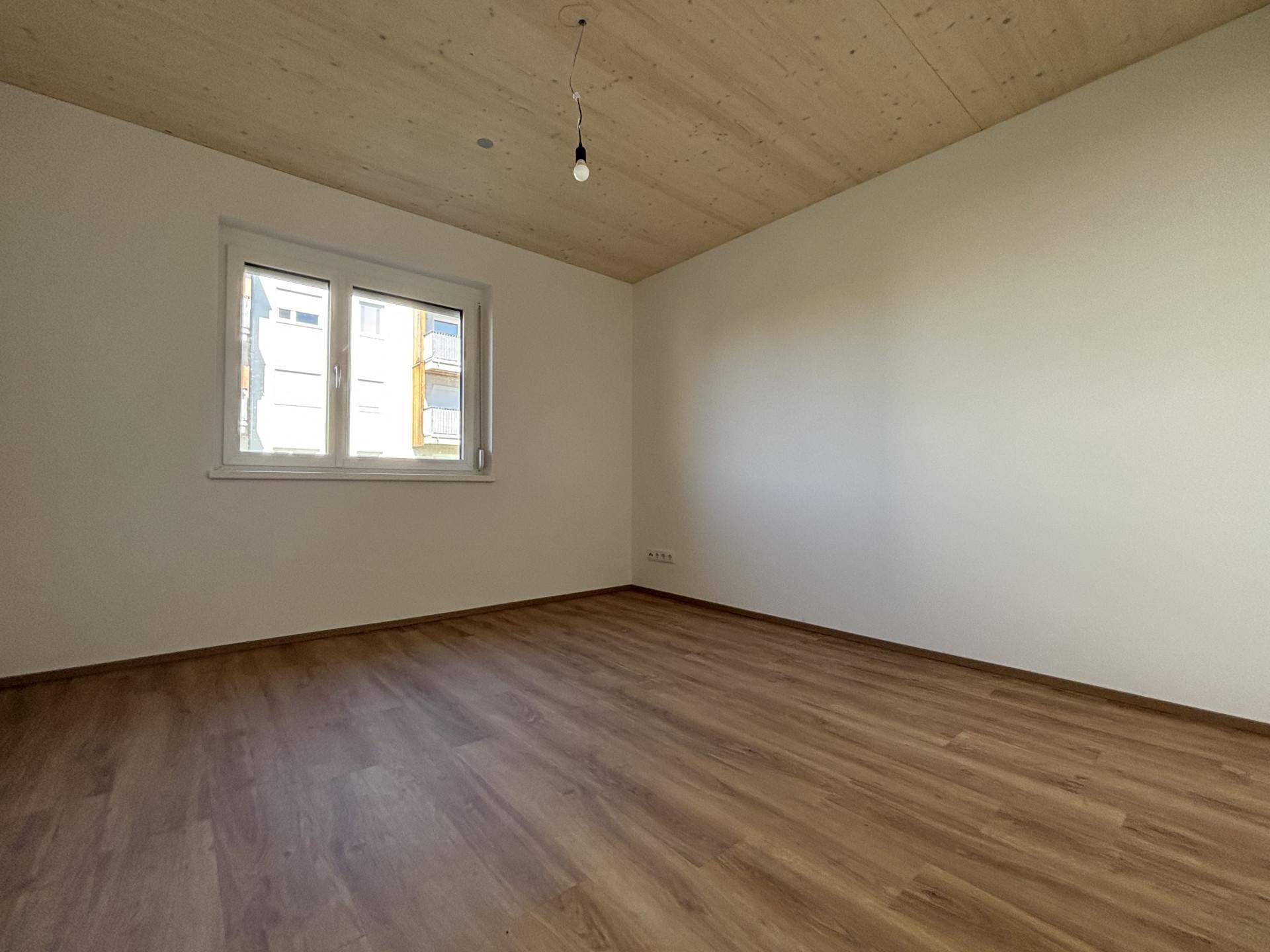 Unmöbliertes Zimmer mit Holzboden und Holzdecke, ideal als Schlaf- oder Arbeitszimmer.