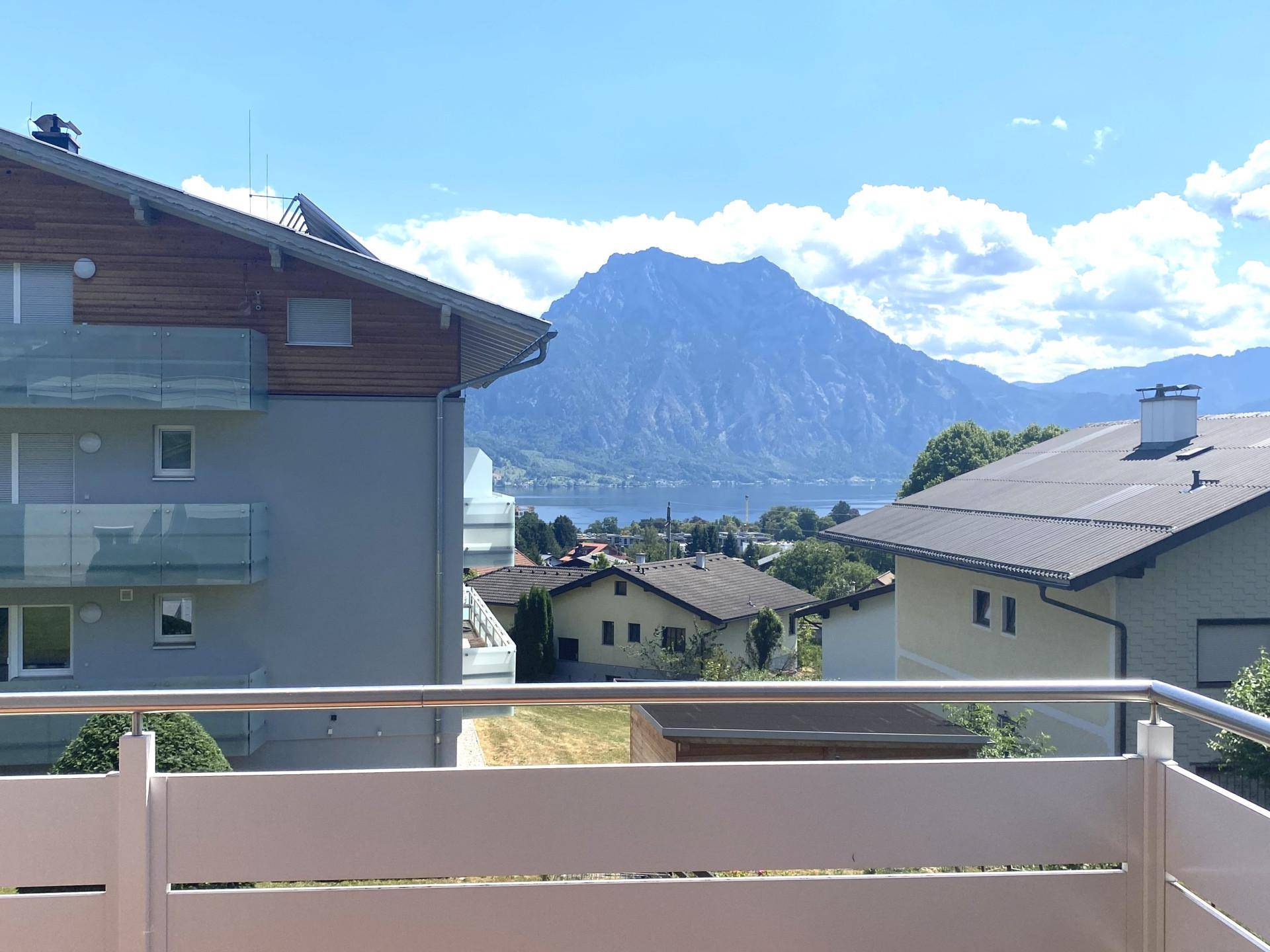 Blick vom Balkon auf den See und die majestätischen Berge in der Ferne.