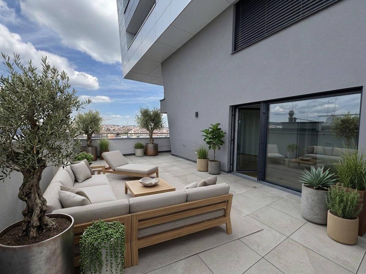 Große, möblierte Dachterrasse mit Pflanzen, Sitzgelegenheiten und weitem Stadtblick.