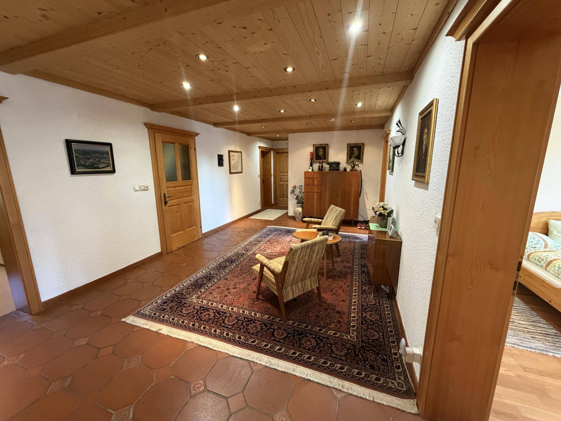 Einladender Flur mit Holzbalkendecke, Terrakottafliesen und traditioneller Einrichtung.