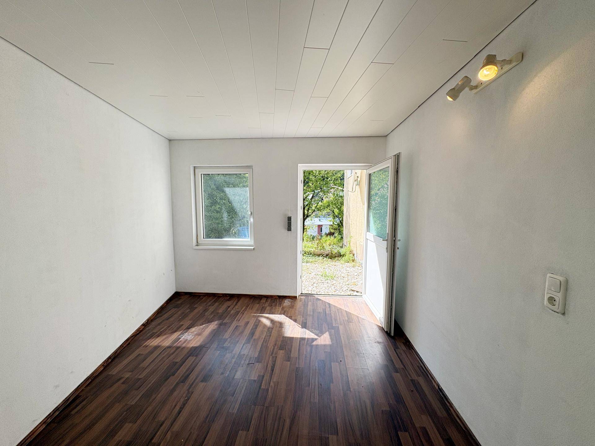 Heller Raum mit Laminatboden und direktem Zugang zum Gartenbereich.