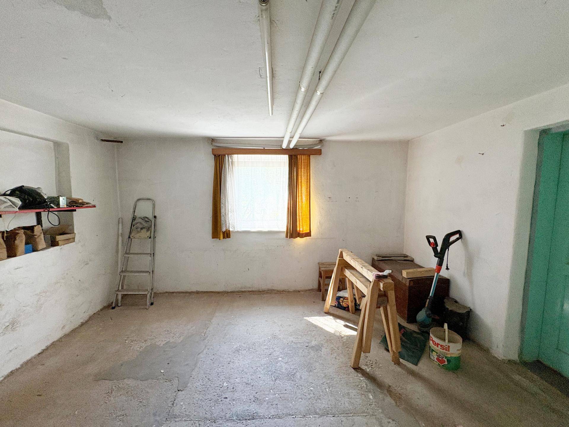 Einfacher Kellerraum mit Fenster, ideal als Abstellraum oder Werkstatt nutzbar.