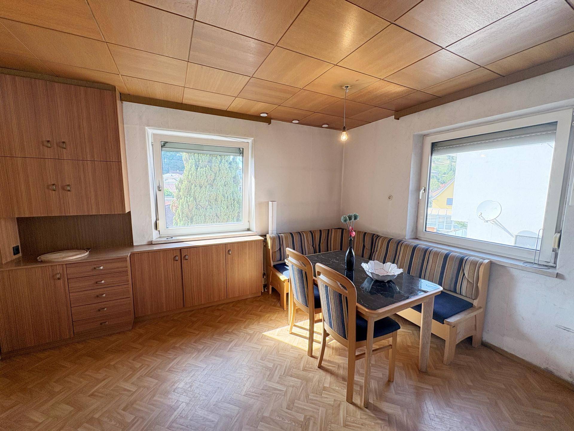 Gemütlicher Essbereich mit Holztisch, Eckbank und Holzvertäfelung an der Decke.