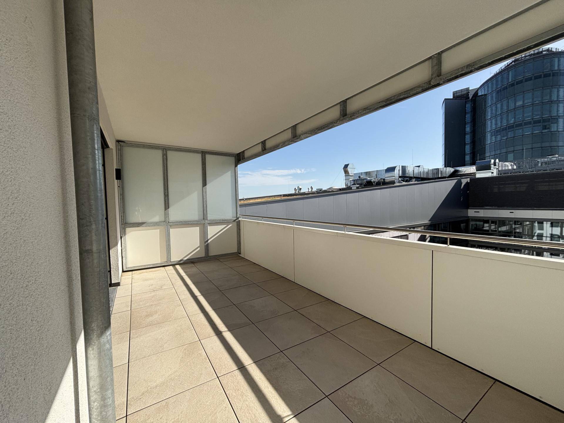 Geräumiger Balkon mit Fliesenboden und weitem Blick über die städtische Umgebung.