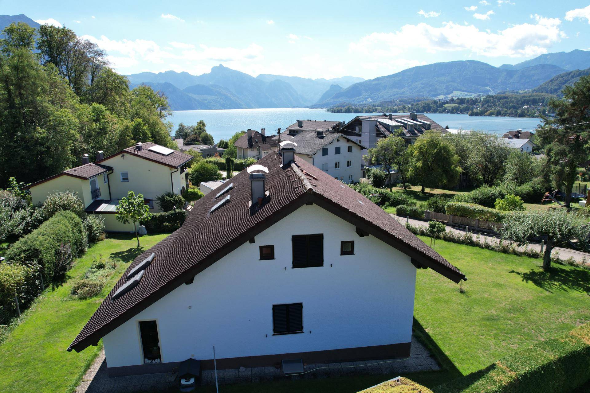 Luftaufnahme des Hauses mit Blick auf den See und die umliegenden Berge.