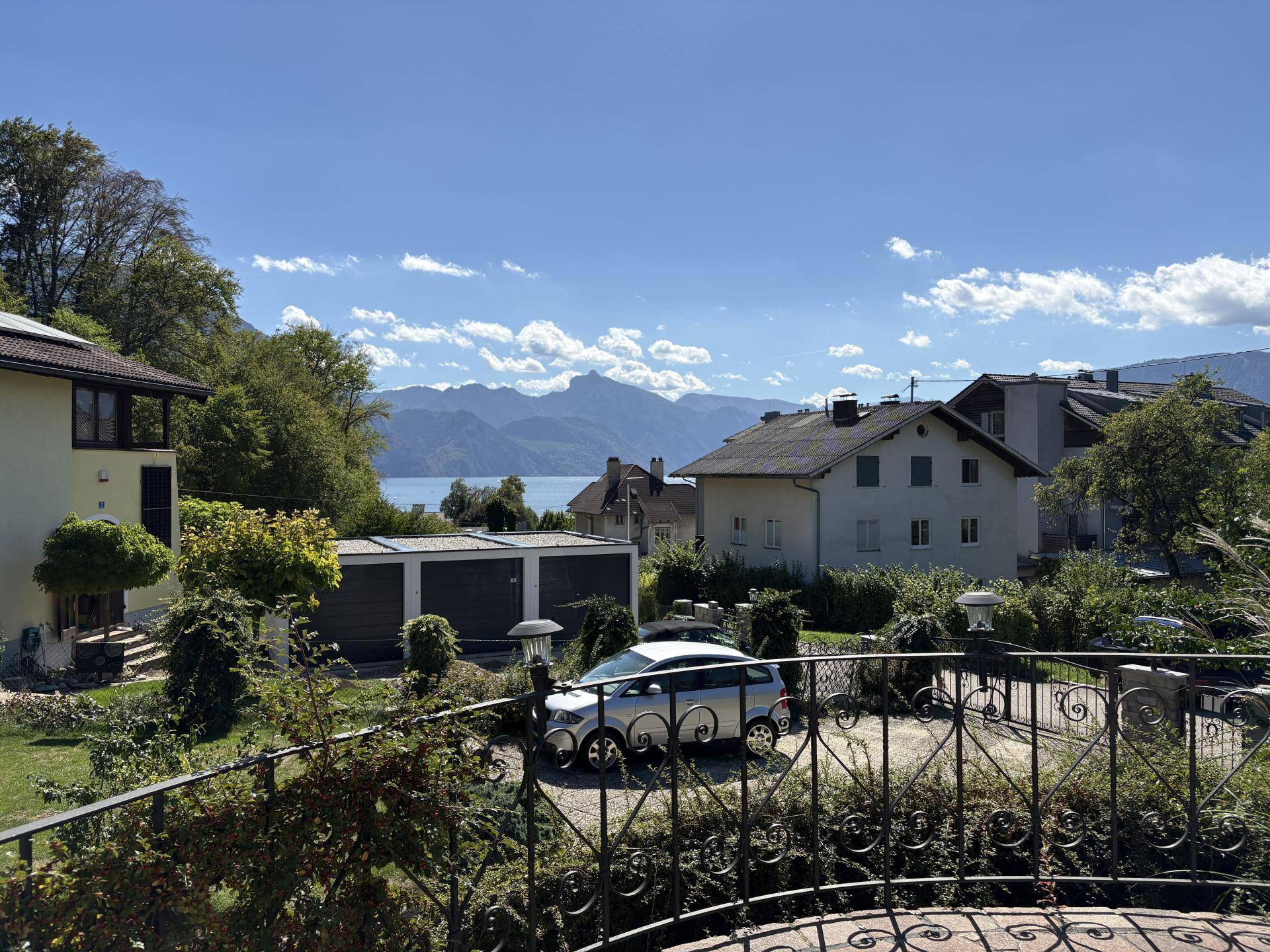 Panoramablick vom Balkon auf den See, die Berge und die umliegende Wohngegend.