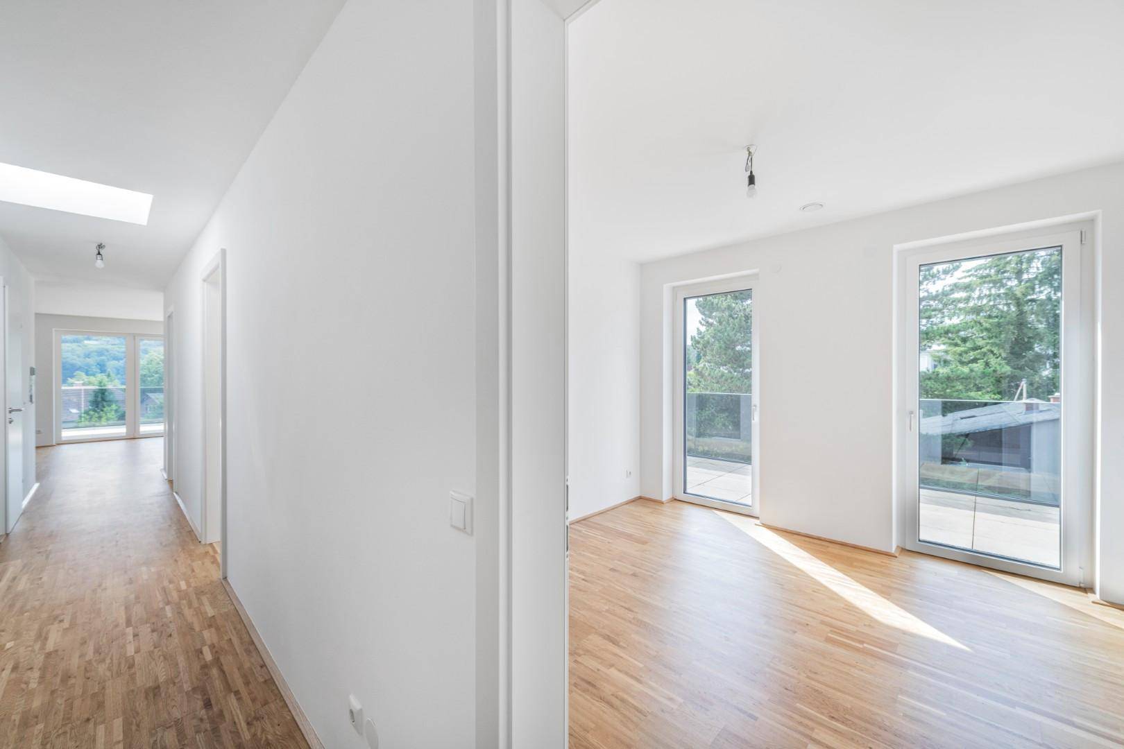 Heller Flur mit Holzboden und Oberlicht, verbindet verschiedene Räume der modernen Wohnung.