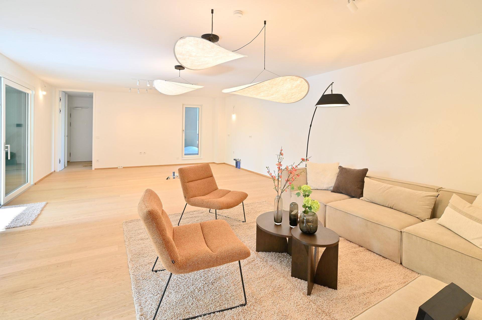 Gemütliches Wohnzimmer mit modernen Möbeln, Holzboden und stilvoller Beleuchtung, hell und einladend.
