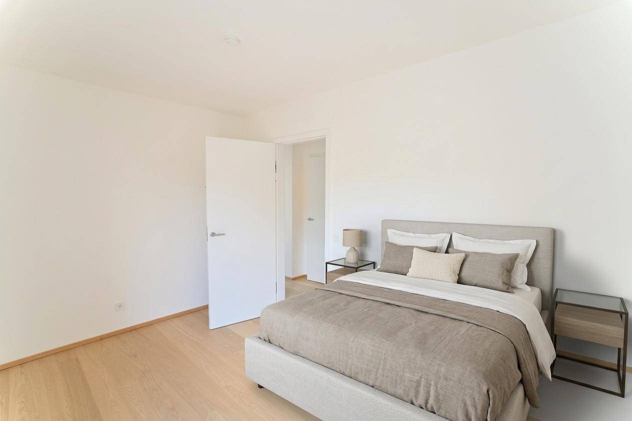 Gemütliches Schlafzimmer mit Holzboden und modernem Bett, bereit zum Einzug.