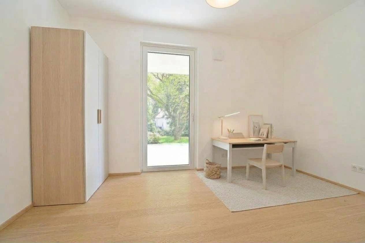 Virtuell inszeniertes Arbeitszimmer mit Schreibtisch, Schrank und Zugang zum Garten.