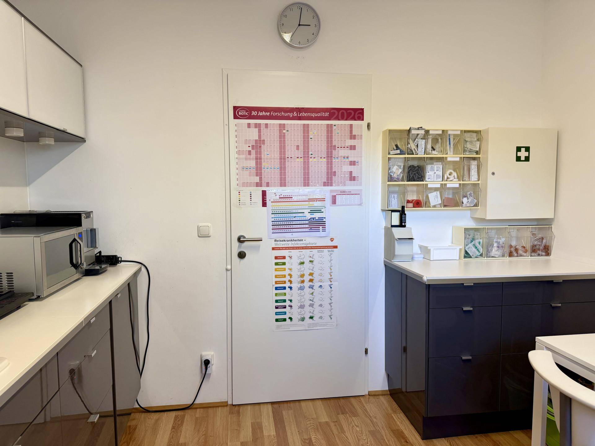 Funktionaler Hauswirtschaftsraum mit Schränken, Mikrowelle und einer Tür mit großem Kalender.